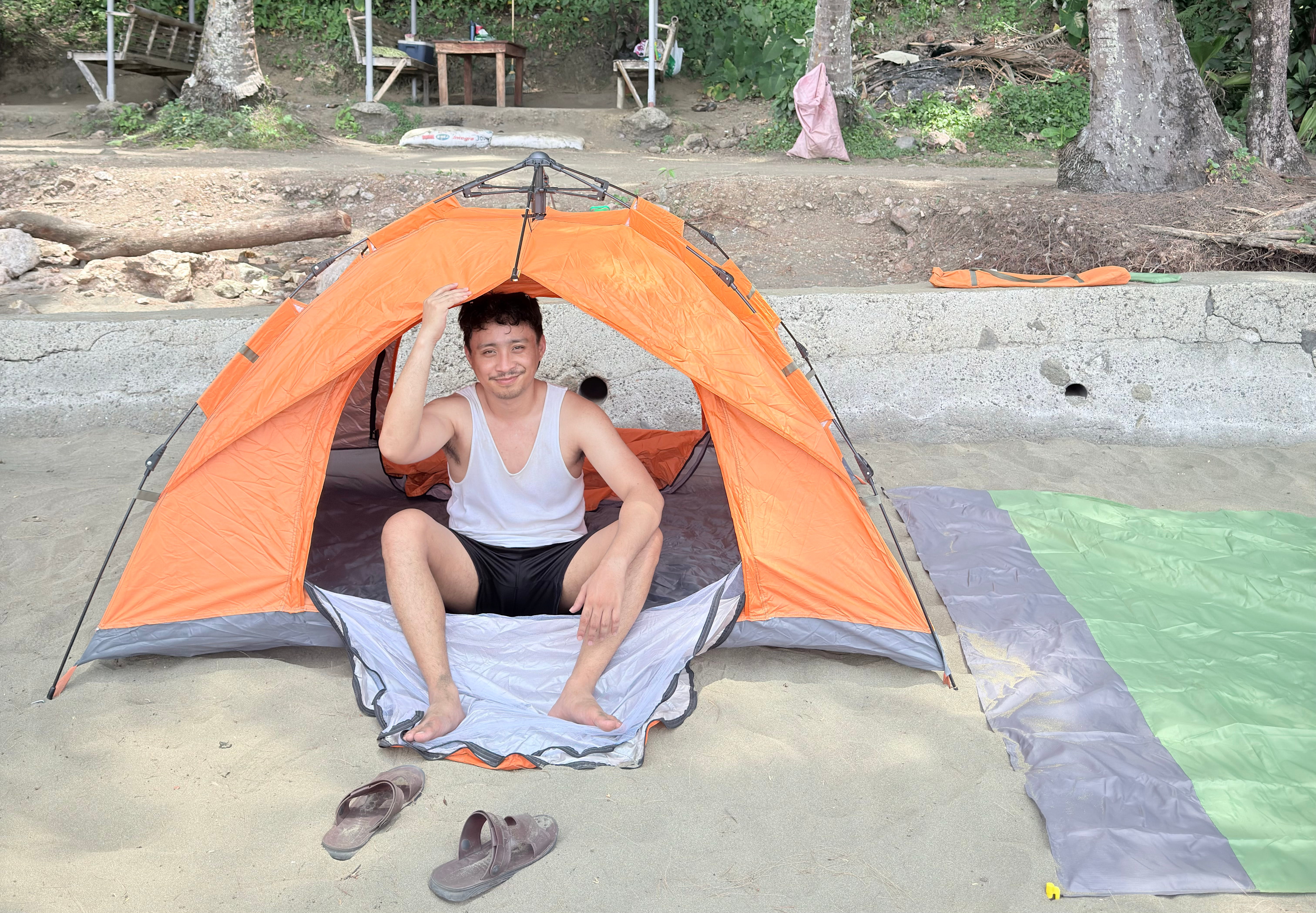 Dylan in a tent at a beach campsite — the nomad life doesn't always look glamorous