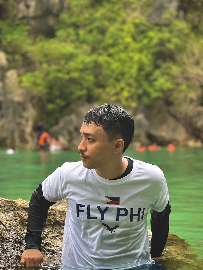 Dylan wearing a Fly Philippines shirt at a crystal lagoon — Filipino pride on the road